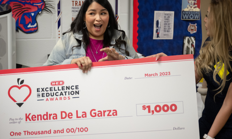 A huge smile as Kendra de La Garza receives an oversized check for 1,000 dollars